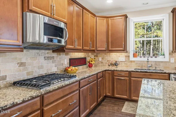 a kitchen with a sink stove top oven and cabinets