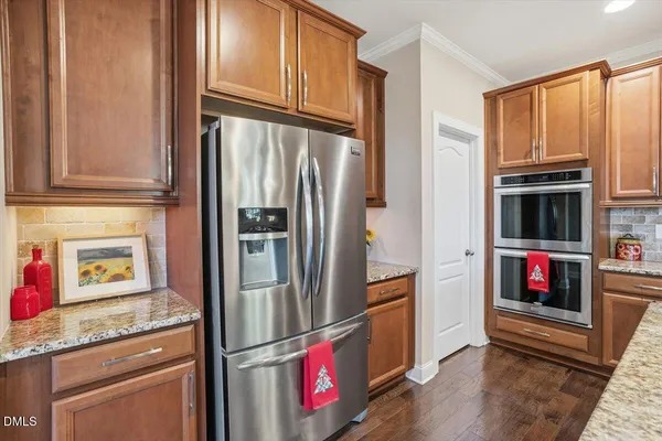 a kitchen with stainless steel appliances granite countertop a refrigerator and a stove