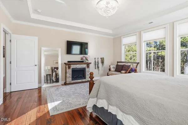 a spacious bedroom with a bed and a flat screen tv