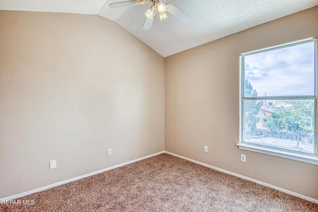 an empty room with fan and windows