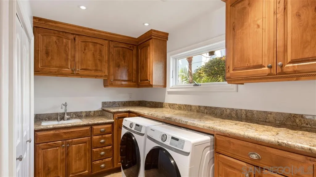 5730 Dolphin Place La Jolla, CA 92037 - Photo 16 of 19 a utility room with granite countertop cabinets washer and dryer