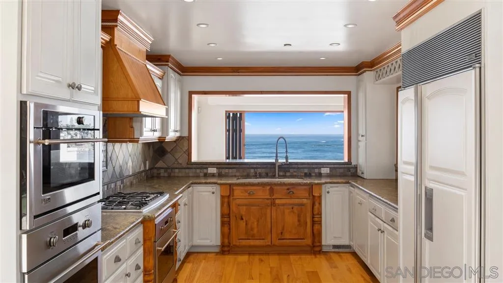 5730 Dolphin Place La Jolla, CA 92037 - Photo 6 of 19 a kitchen with granite countertop a stove and a refrigerator