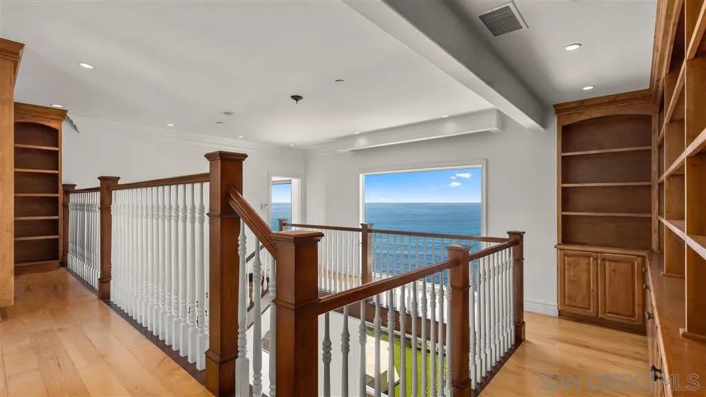5730 Dolphin Place La Jolla, CA 92037 - Photo 10 of 19 a view of a hallway with wooden floor and stairs