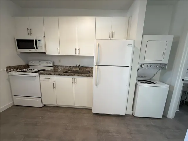 a white refrigerator freezer and a stove sitting inside of a kitchen