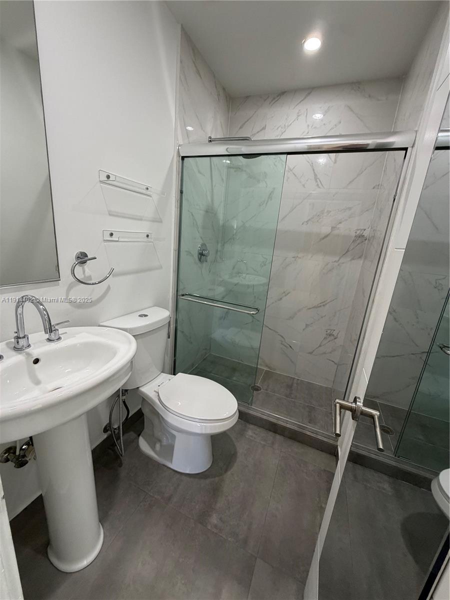3051 Southwest 27th Lane, Unit 3 Miami, FL 33133 - Photo 5 of 8 a bathroom with a sink toilet and shower