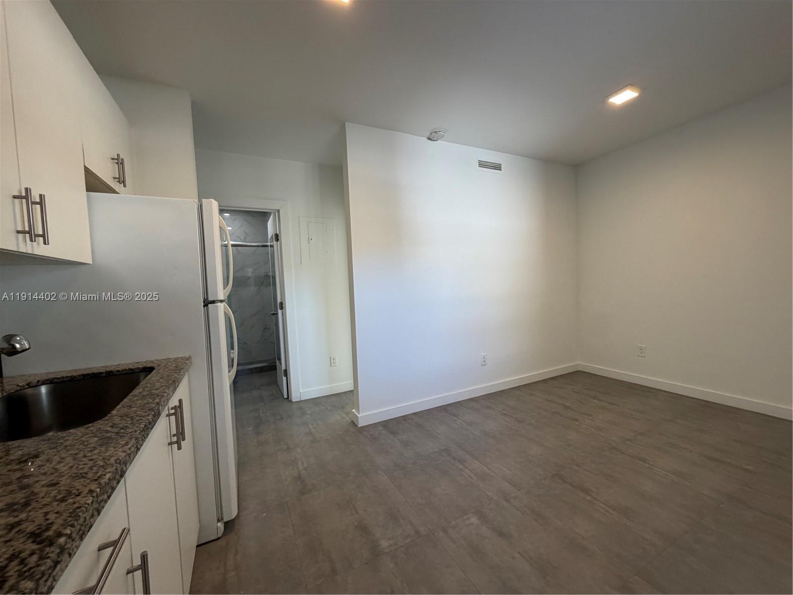 3051 Southwest 27th Lane, Unit 3 Miami, FL 33133 - Photo 6 of 8 a kitchen with a refrigerator and a sink