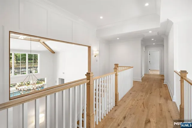 a view of a hallway with wooden floor and staircase
