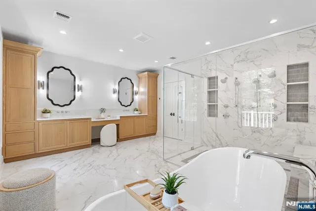 a bathroom with a tub a sink and a large mirror