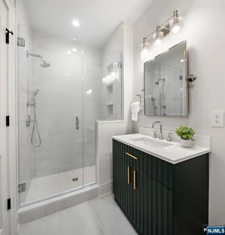 a bathroom with a shower sink vanity and mirror