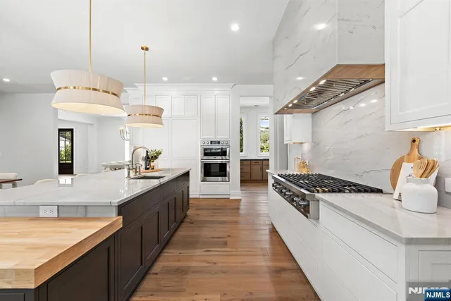 a kitchen with stainless steel appliances granite countertop a stove a sink and a refrigerator