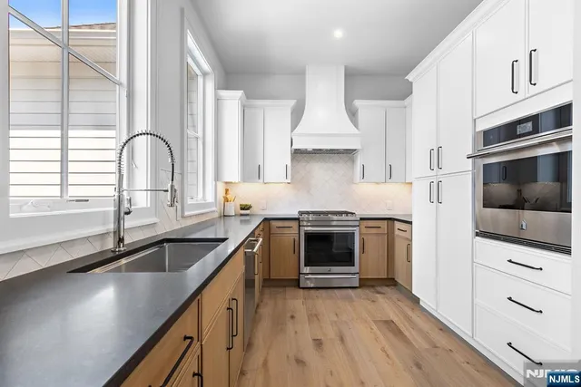 a kitchen with stainless steel appliances a sink stove and cabinets
