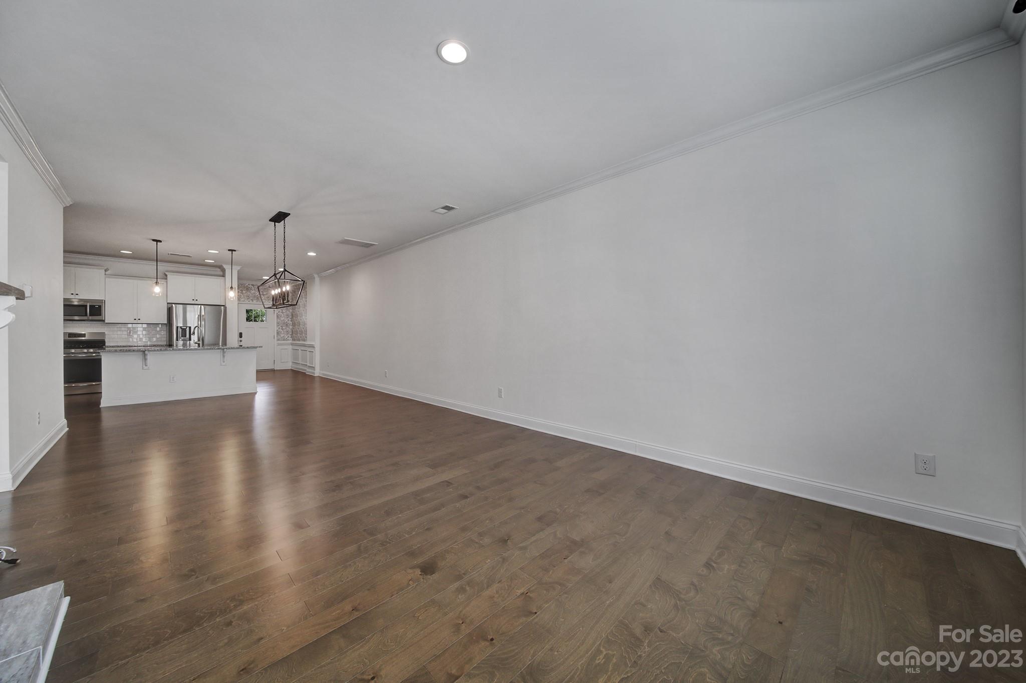 5072 Gribble Lane Lancaster, SC 29720 - Photo 12 of 34 an empty room with wooden floor and a kitchen