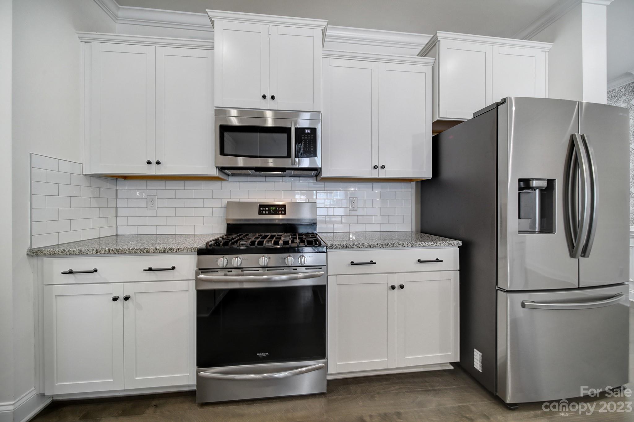 5072 Gribble Lane Lancaster, SC 29720 - Photo 8 of 34 a kitchen with stainless steel appliances white cabinets white stove a refrigerator and a microwave