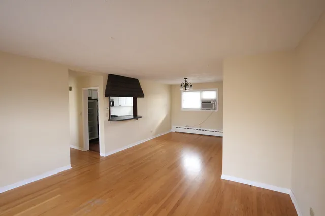 a view of empty room with wooden floor and window
