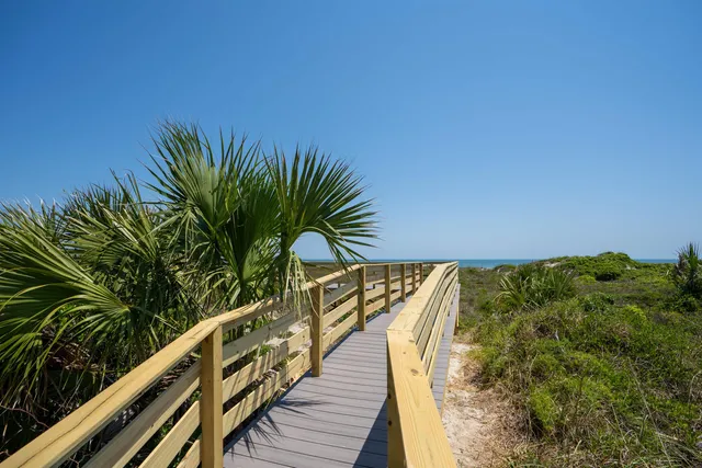 an aerial view of ocean and residential houses with outdoor space