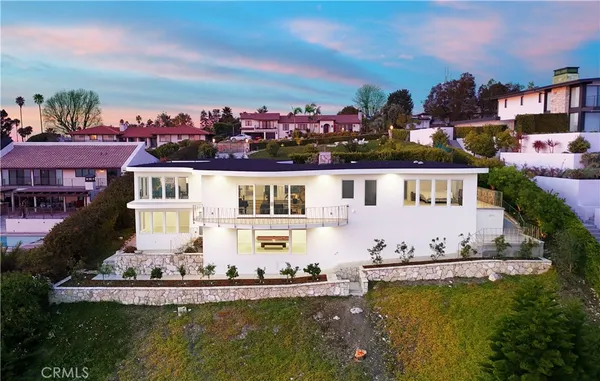 an aerial view of a house with a garden and lake view