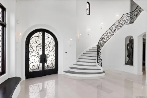 a room with lots of white furniture and glass door