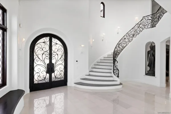 a room with lots of white furniture and glass door
