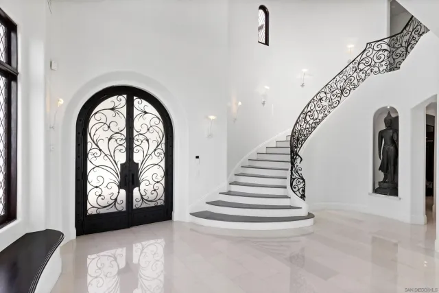 a room with lots of white furniture and glass door