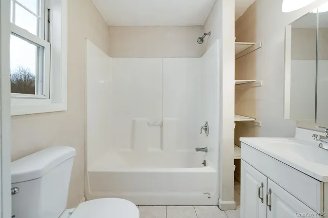a bathroom with a bathtub shower sink vanity and toilet