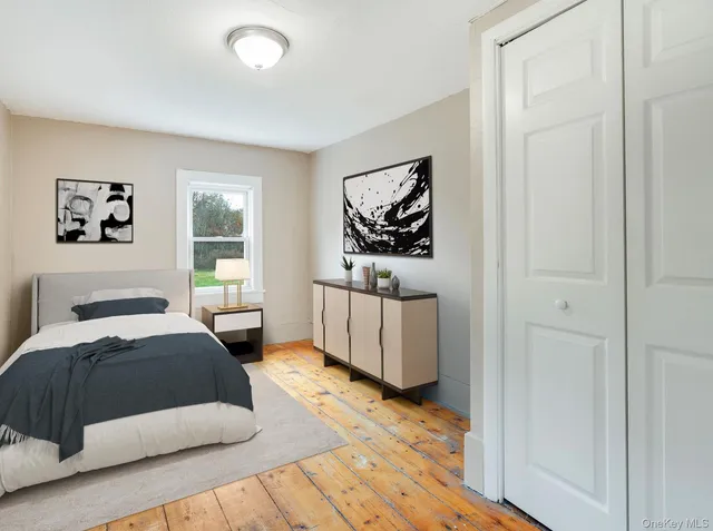 a bedroom with a bed and a painting on the wall