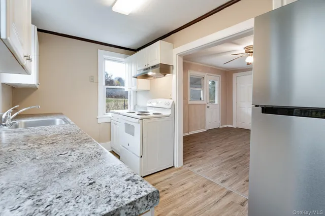 a view of a kitchen with wooden floor and a sink