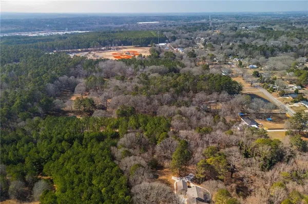 an aerial view of residential houses with outdoor space and trees