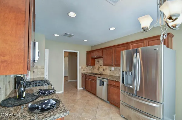 a kitchen with stainless steel appliances granite countertop a refrigerator and a stove