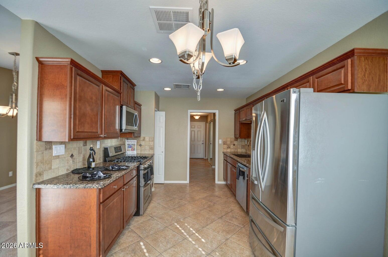 3022 North 34th Place Phoenix, AZ 85018 - Photo 12 of 40 a kitchen with stainless steel appliances granite countertop a refrigerator a sink dishwasher a stove and a dining table with wooden floor