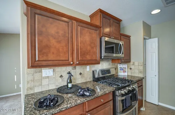 a kitchen with granite countertop cabinets and steel stove top oven