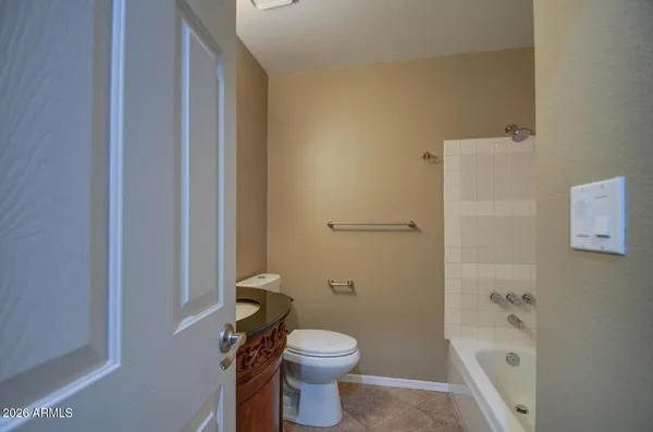 a white toilet sitting next to a bathroom sink and vanity