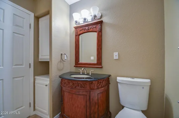 a bathroom with a granite countertop toilet sink and mirror