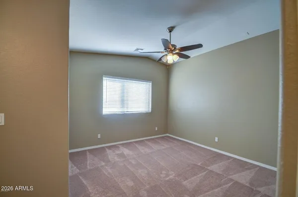 an empty room with a ceiling fan and a window
