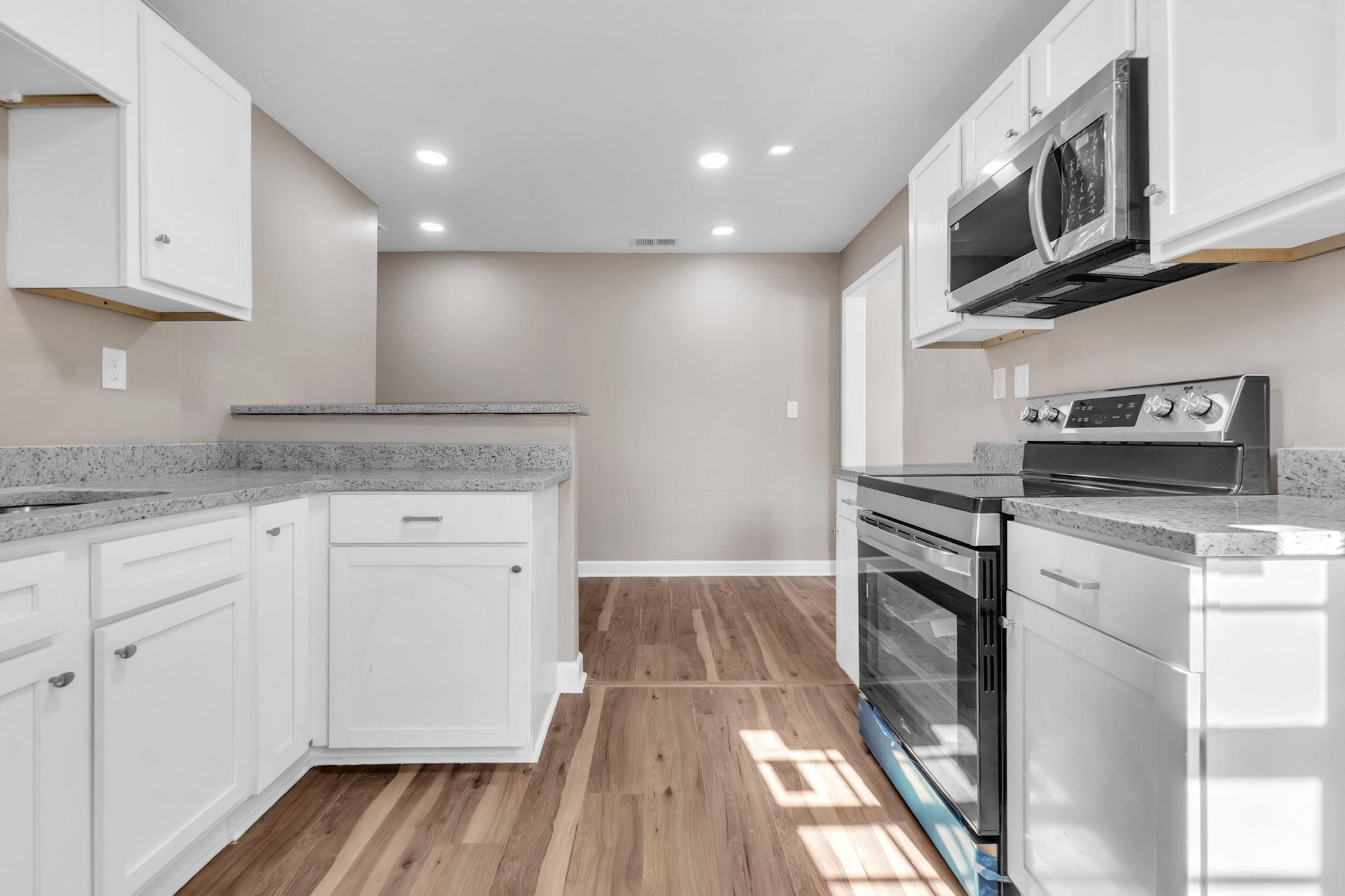 375 Pope Street Memphis, TN 38112 - Photo 14 of 19 Kitchen featuring stainless steel appliances, white cabinetry, light stone countertops, and recessed lighting