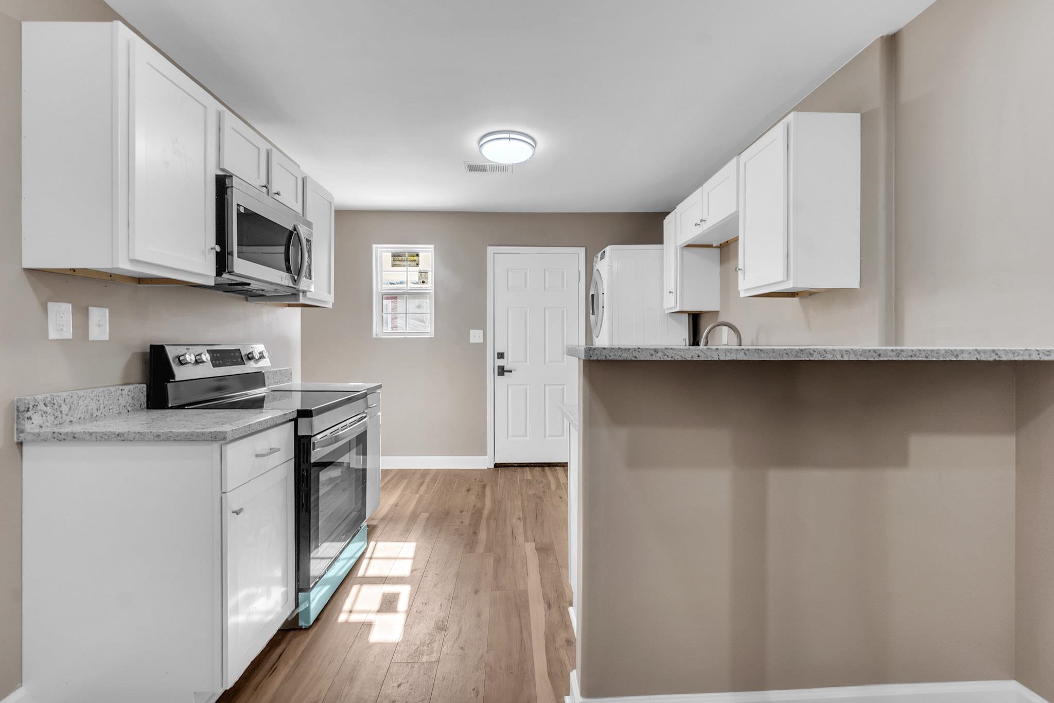 375 Pope Street Memphis, TN 38112 - Photo 17 of 19 Kitchen featuring white cabinetry, stainless steel appliances, light wood finished floors, and a peninsula