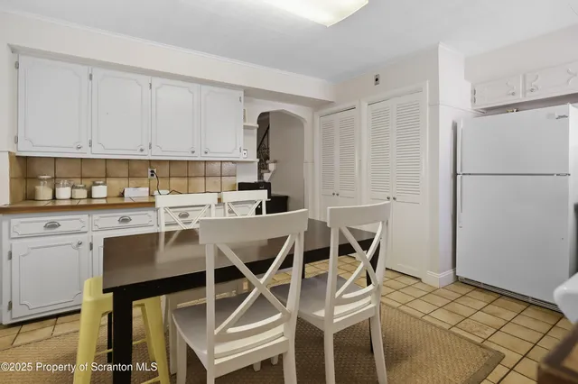 a view of a dining room with furniture a chandelier and wooden floor
