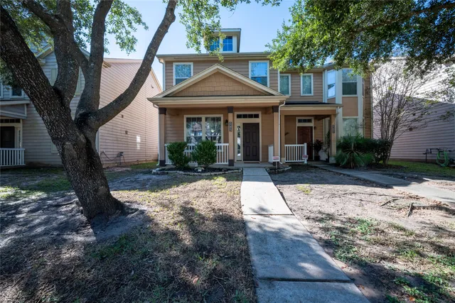 a front view of a house with yard and tree