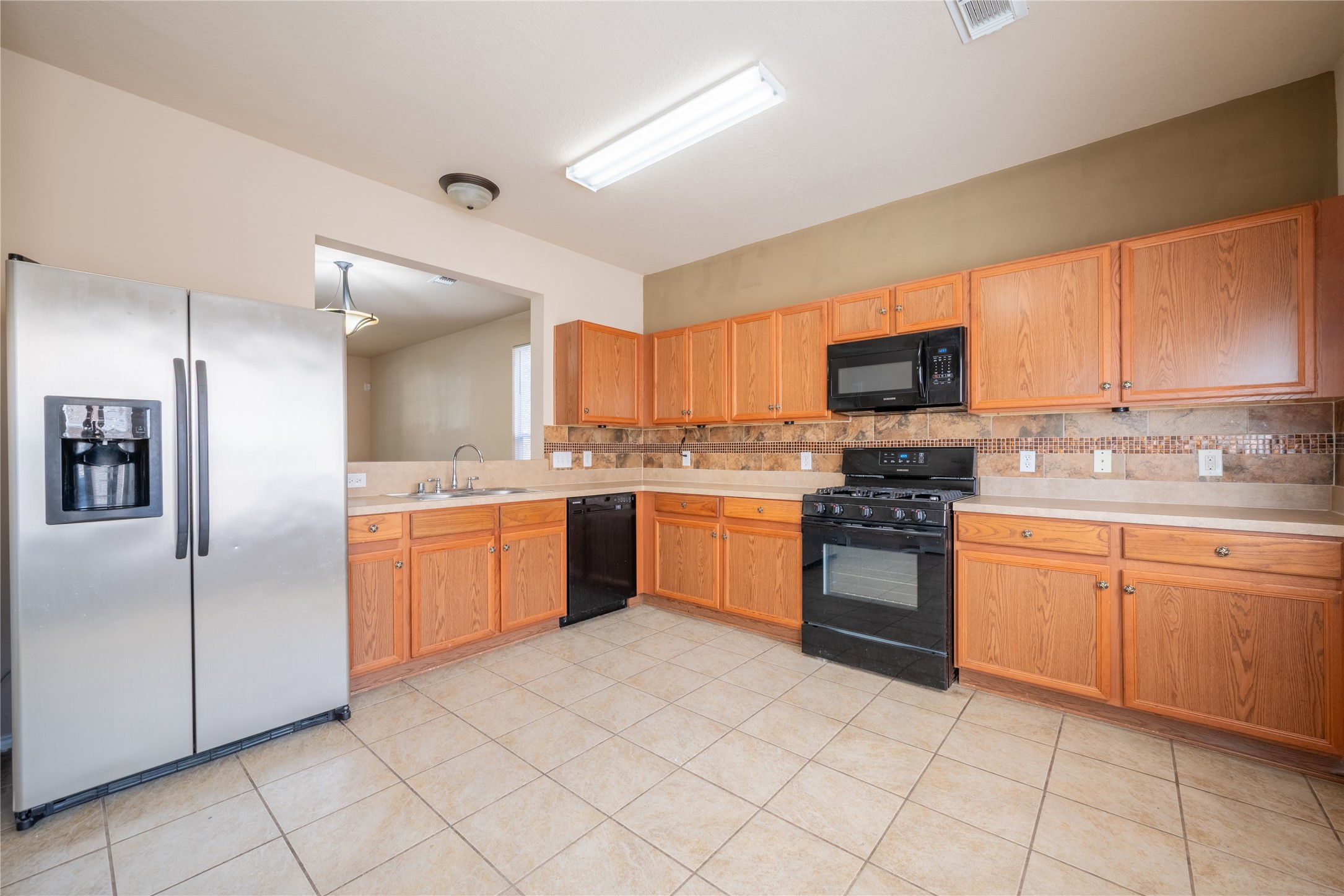23823 Pebworth Place Spring, TX 77373 - Photo 6 of 31 a kitchen with stainless steel appliances granite countertop a stove top oven a sink dishwasher and a refrigerator
