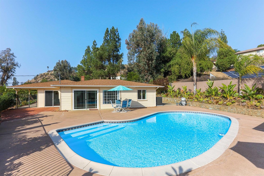 1188 Crystal Lane El Cajon, CA 92020 - Photo 22 of 26 a view of a house with pool fire pit a chairs and potted plants
