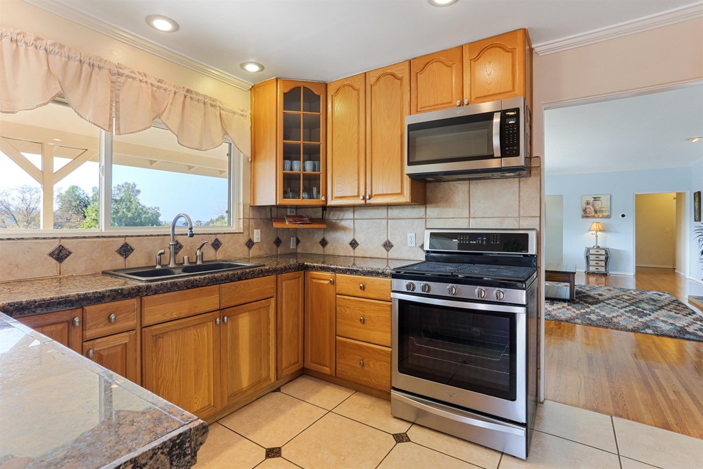 1188 Crystal Lane El Cajon, CA 92020 - Photo 8 of 26 a kitchen with stainless steel appliances a stove sink and microwave