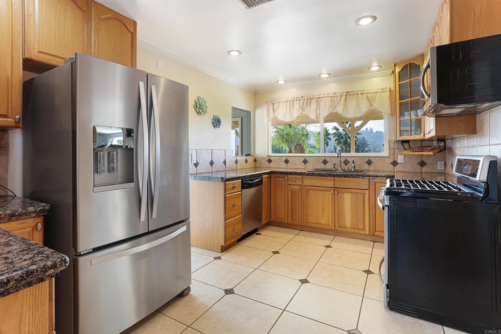 1188 Crystal Lane El Cajon, CA 92020 - Photo 9 of 26 a kitchen with stainless steel appliances granite countertop a refrigerator a stove a sink and a microwave