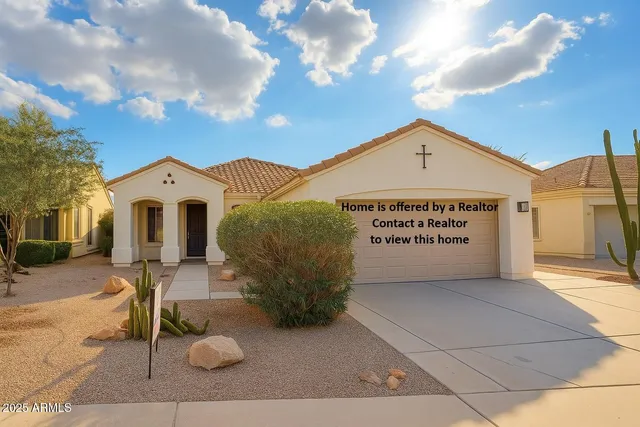 a view of a white house with a large tree