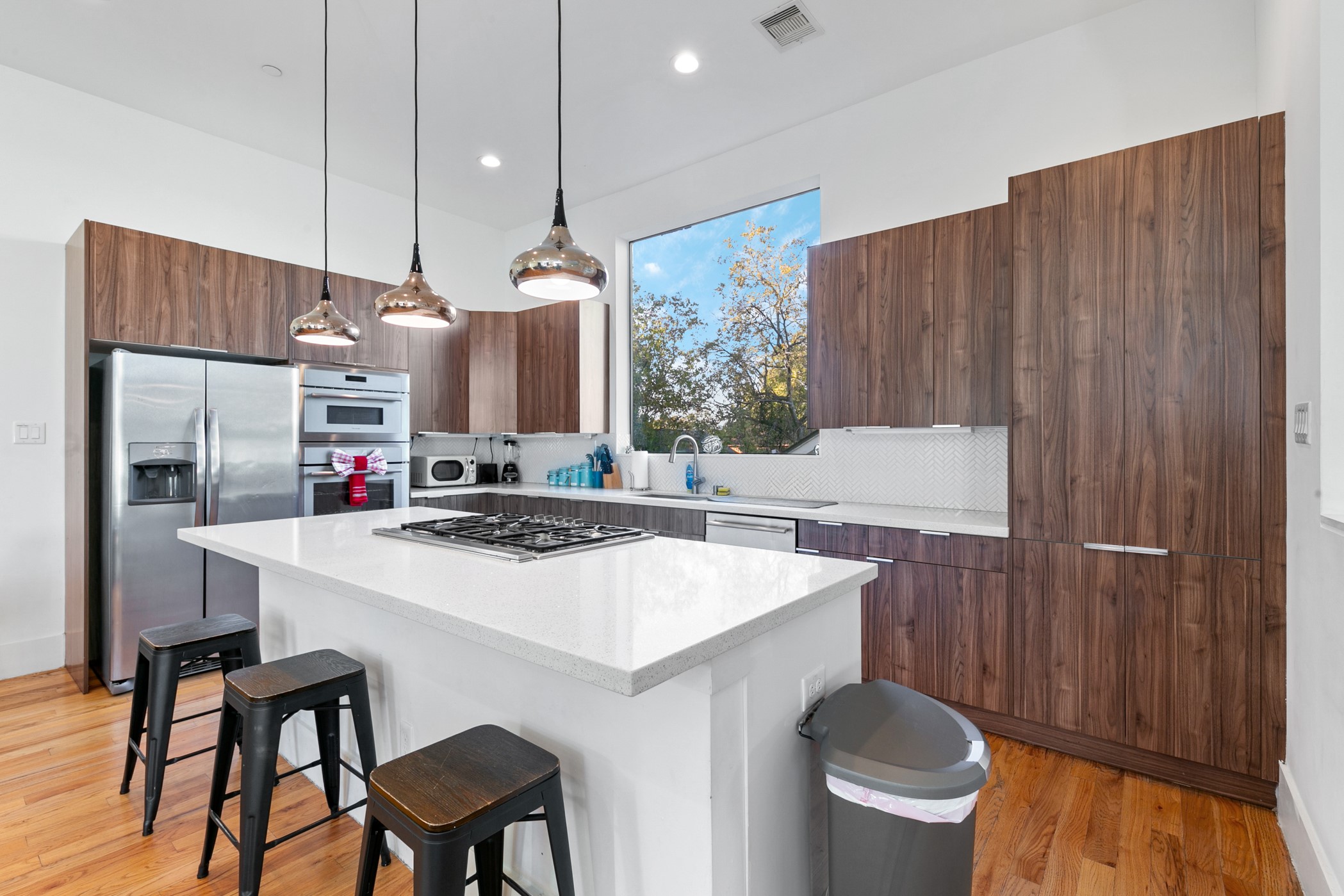 604 Oakley Street Houston, TX 77006 - Photo 14 of 38 A striking oversized quartz island featuring a built in gas cooktop that anchors the kitchen with style and function.
