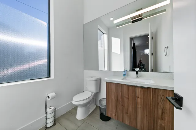 a bathroom with a granite countertop sink mirror vanity and toilet