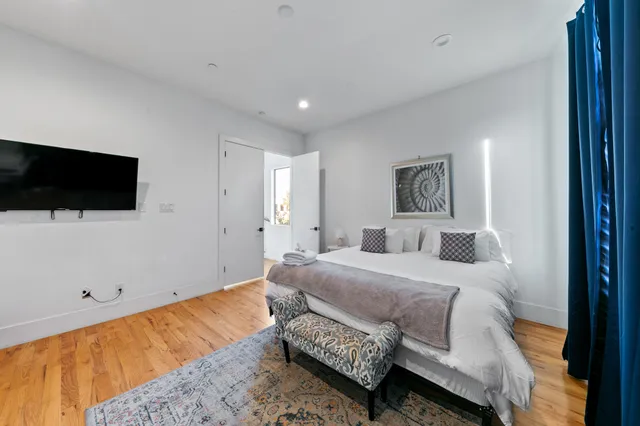 a bedroom with a bed and a flat screen tv