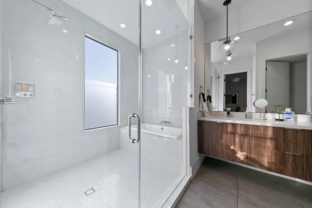a bathroom with a double vanity sink a large mirror and shower