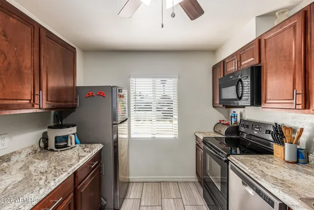 a kitchen with granite countertop stainless steel appliances window a sink and a counter space
