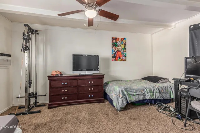 a bedroom with a bed and a flat tv screen on dresser