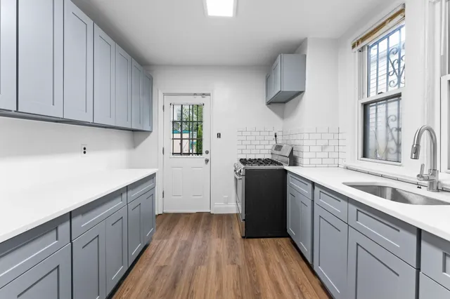a kitchen with a sink dishwasher stove and cabinets