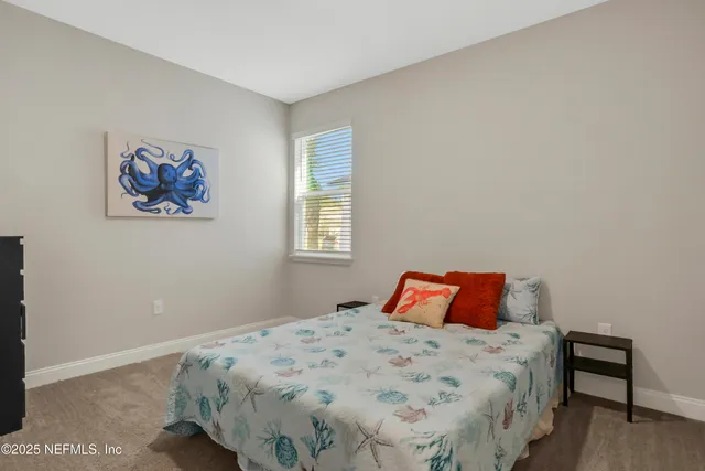 a bedroom with a bed and a lamp on dresser